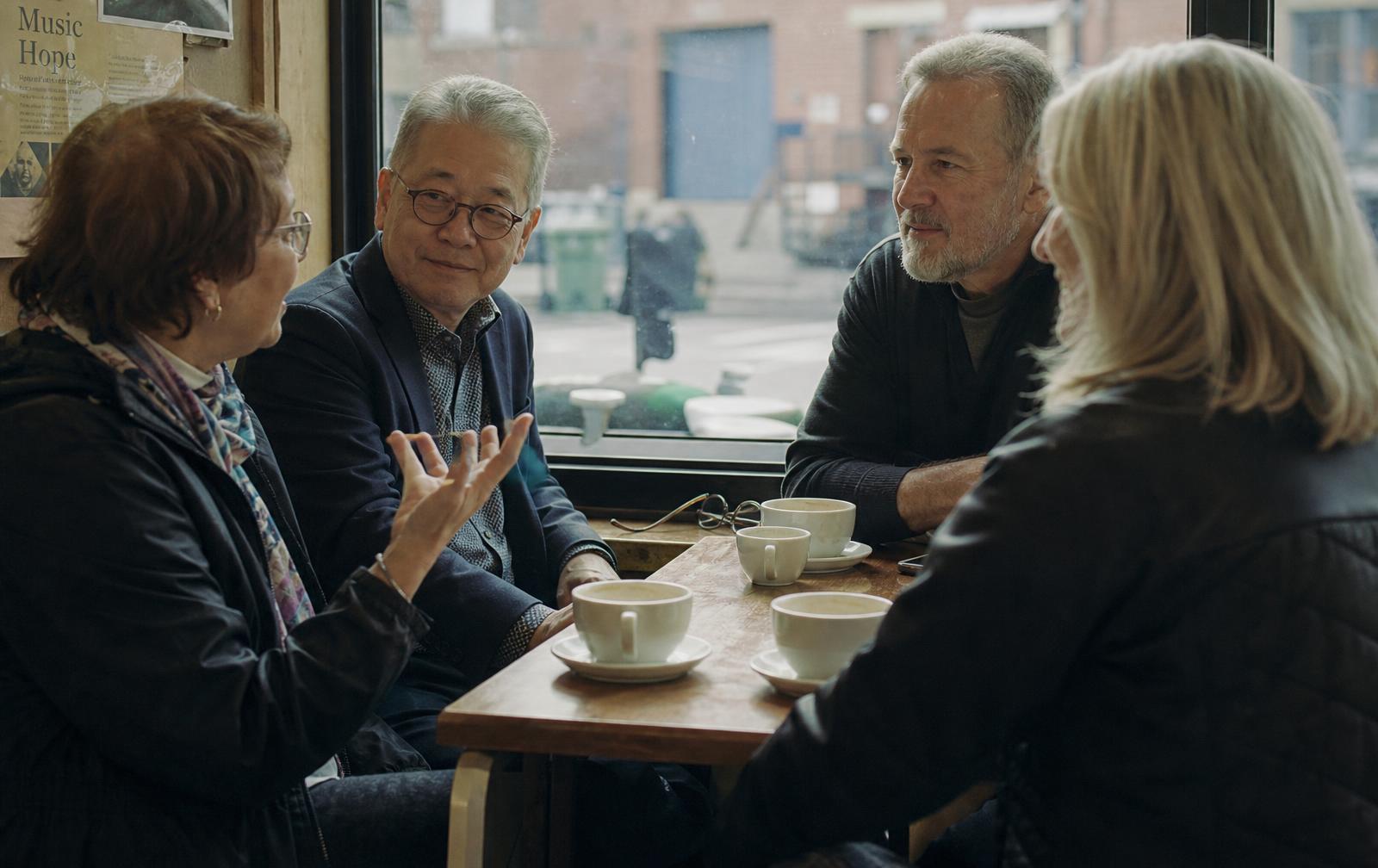Adults in conversation over coffee